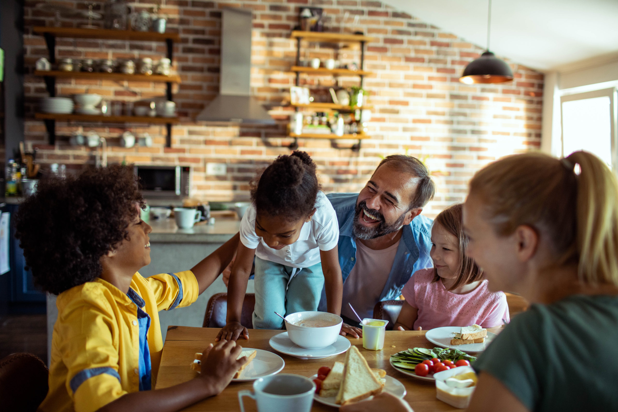 Father having fun with his diverse children at home